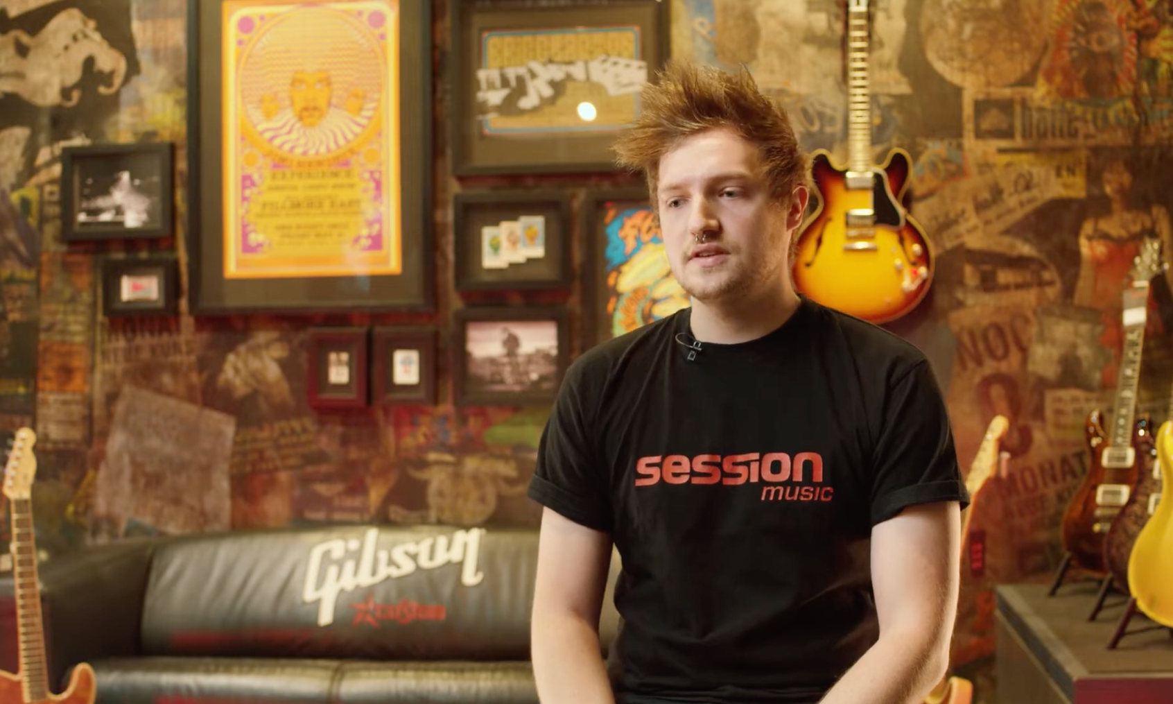 Ein Verkäufer sitzt vor einer Wand voller Instrumente